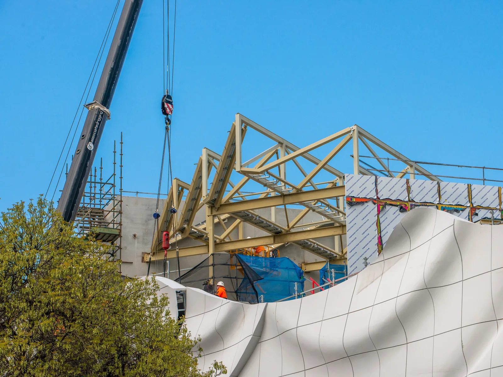 Roof trusses craned into place above the curved facade at the Geelong Arts Centre build