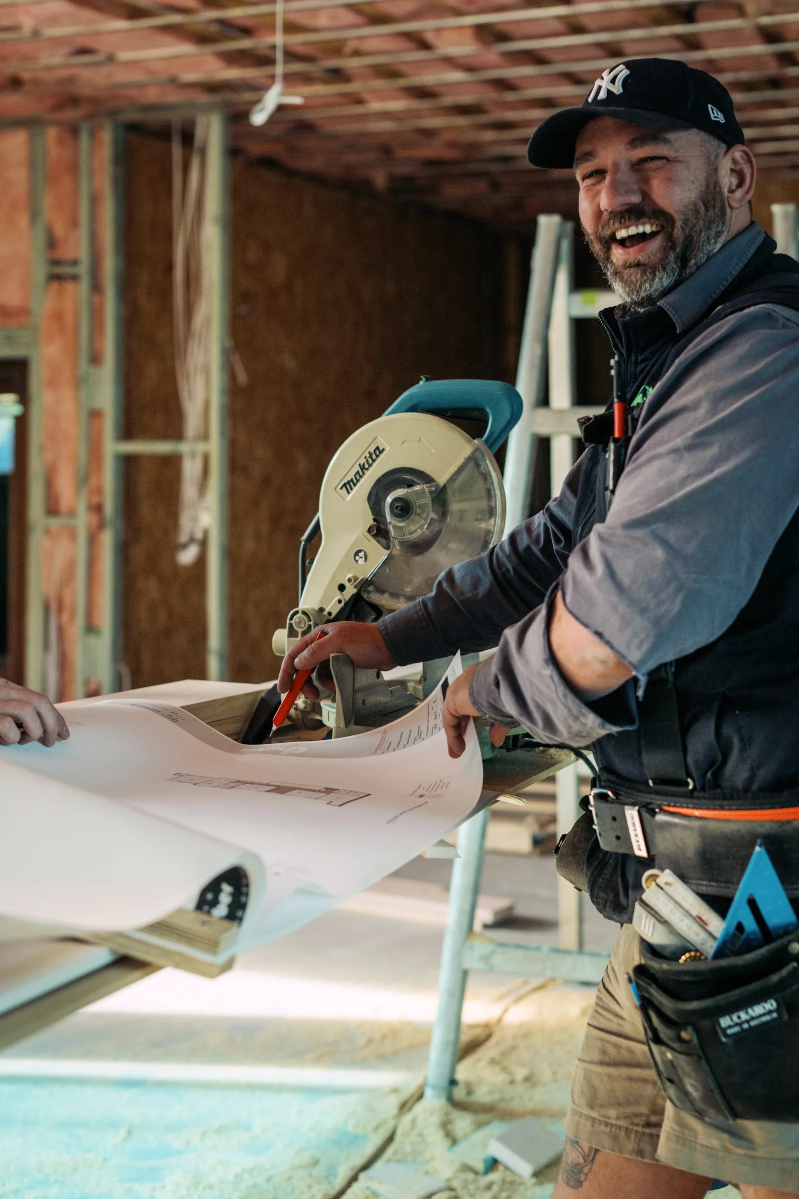 Carpenter on the drop saw during a build at Chesterfield Court, Newtown
