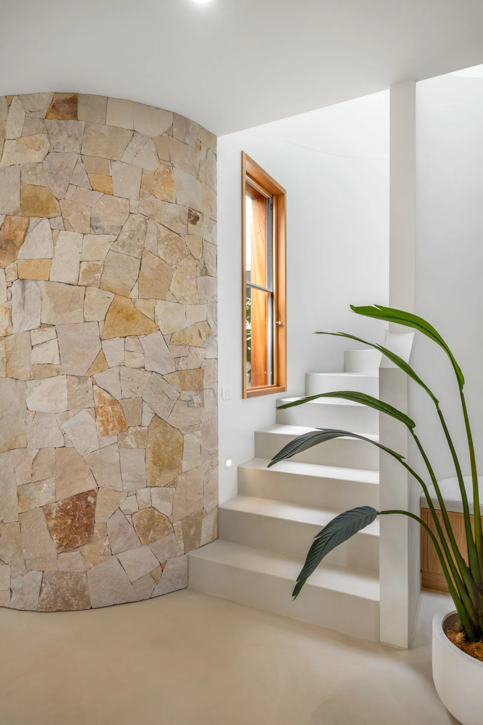 Curved stone feature wall and staircase in a custom build at Miranda Close, Torquay