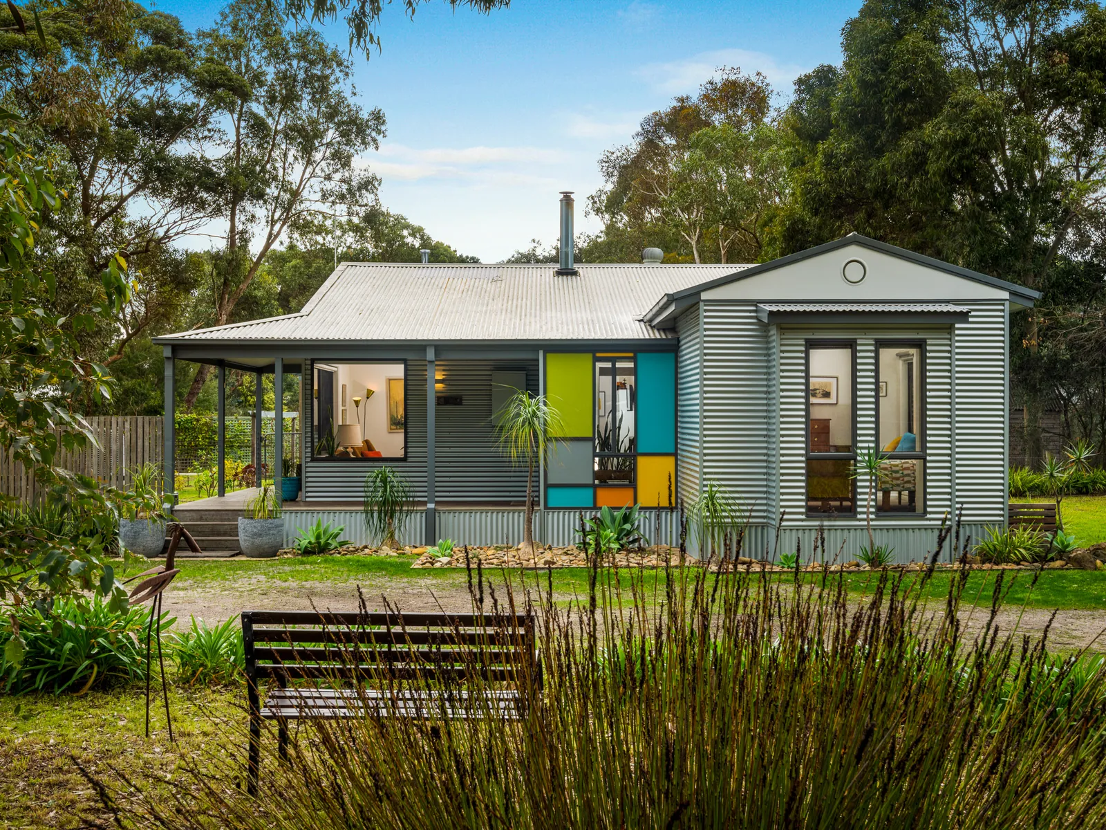 Weatherboard cottage with leadlight windows and a cottage garden, Indented Head