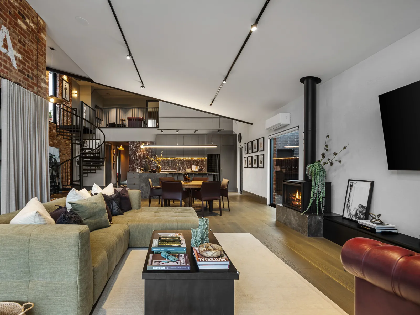 Living room with exposed brick, wood fire and spiral staircase, North Geelong